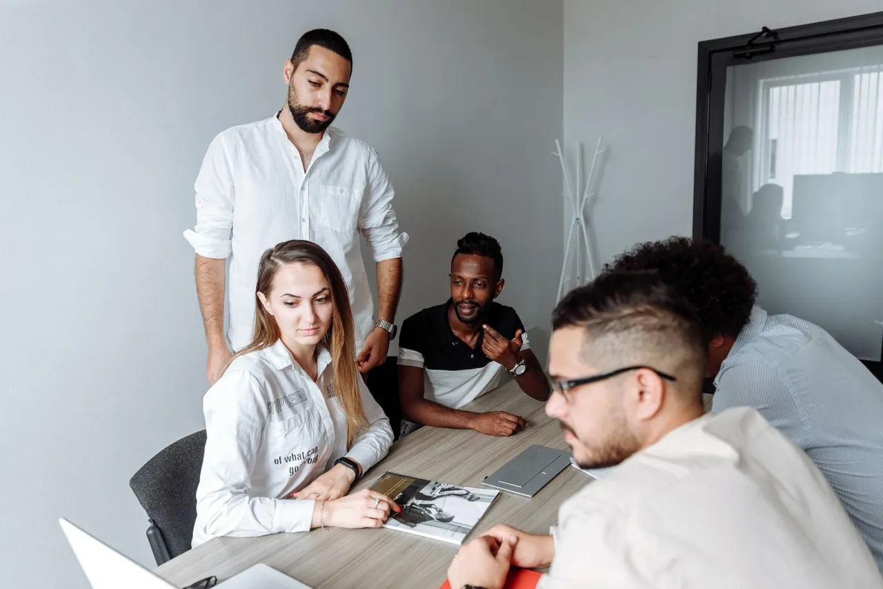 Colleagues reviewing documents and a laptop around a meeting table