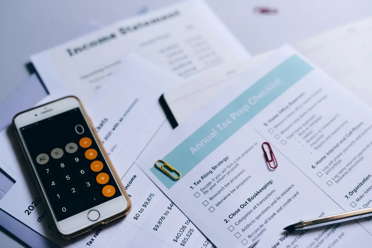 Printed financial documents with a checklist and calculator
