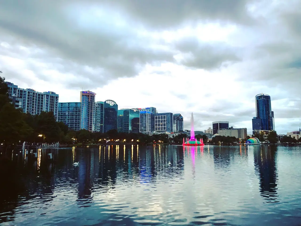 Downtown Orlando buildings and the Lake Eola fountain reflected in the water